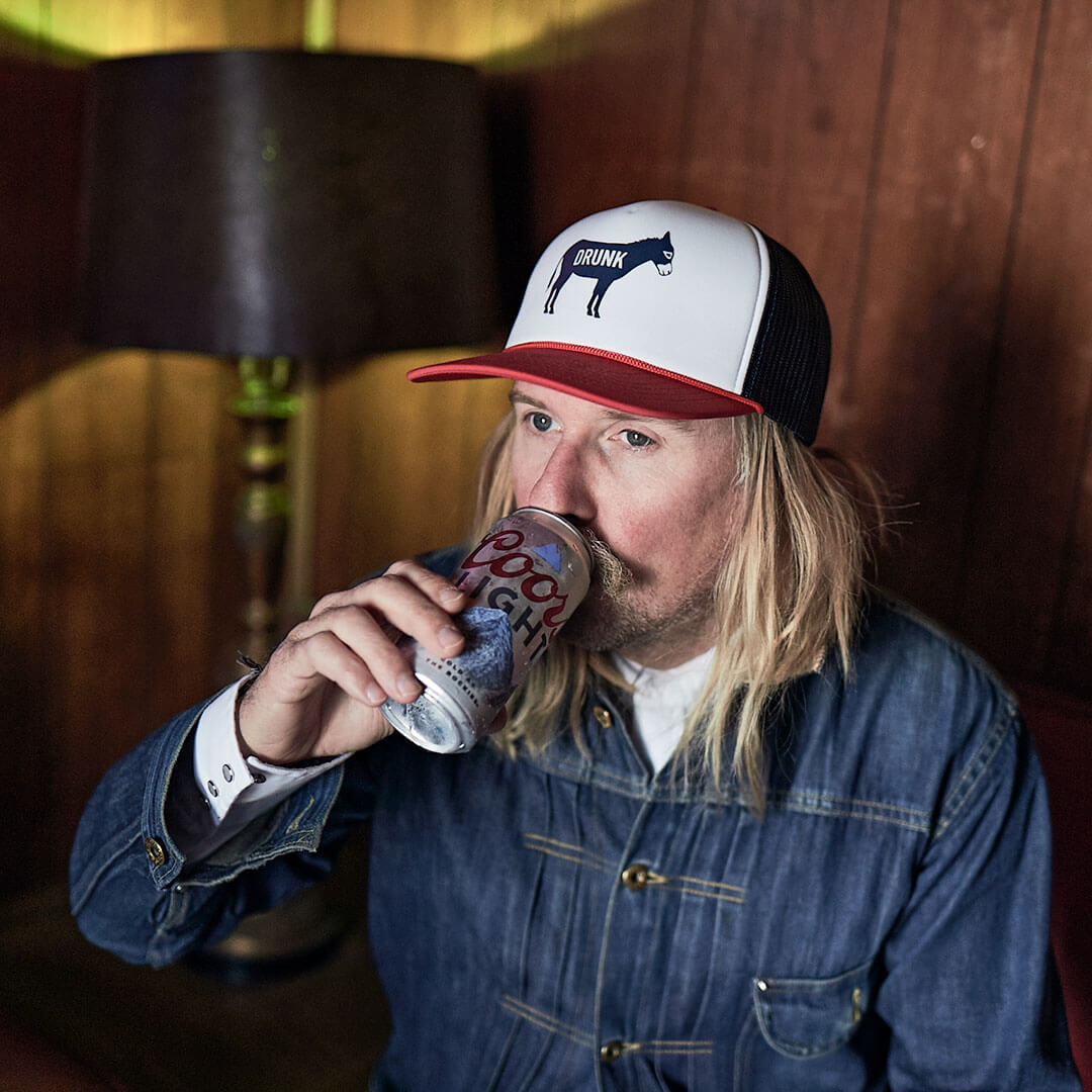 A man drinking a beer and wearing a Cowboy Cool Drunk Ass Hat