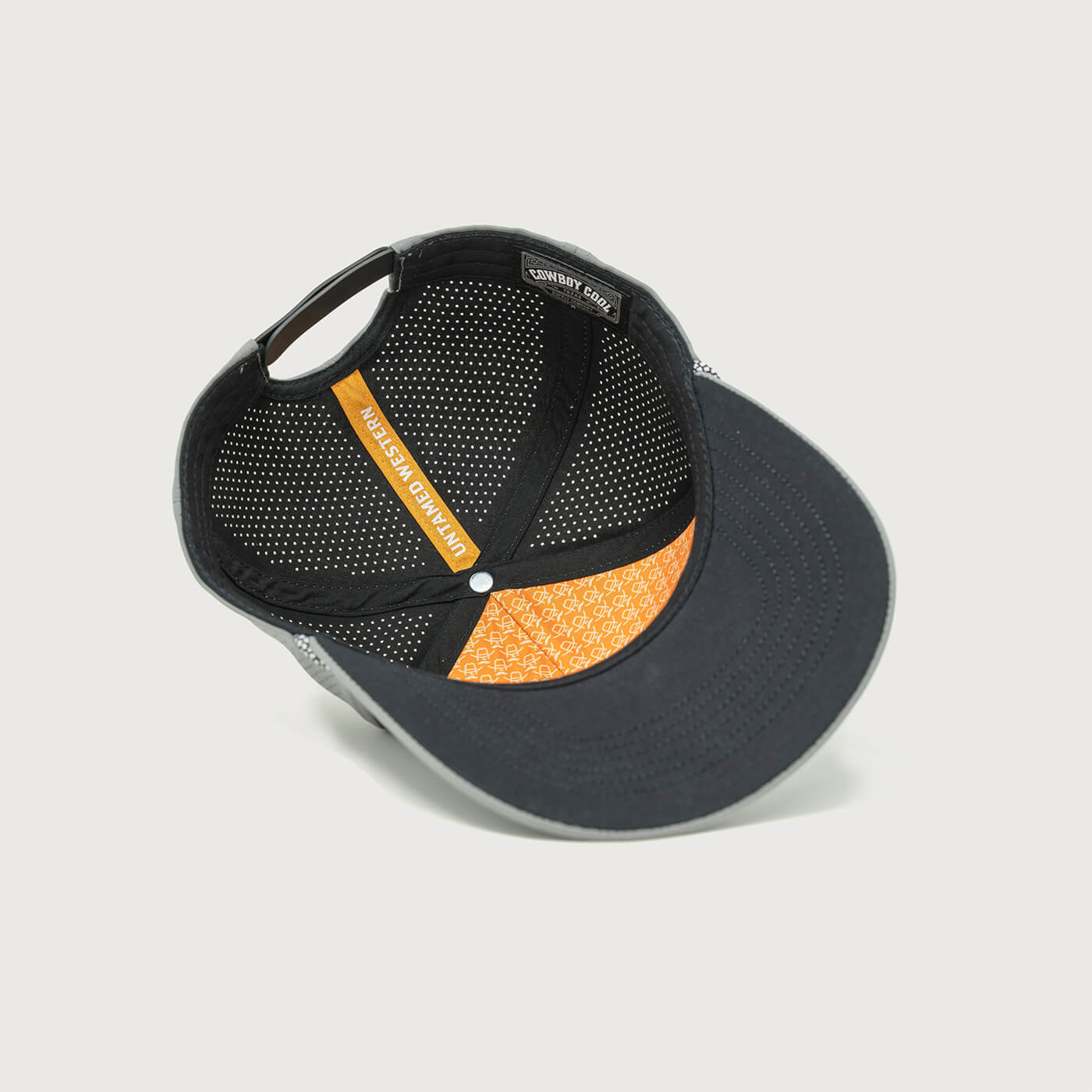 Interior view of the Cowboy Cool Maverick Hat showcasing the perforated lining, orange custom taping with 'Untamed Western' text, and branded detailing.