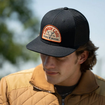 Man wearing Cowboy Cool Badlands Hat in black with bison skull patch and Untamed Western branding, snapback trucker style