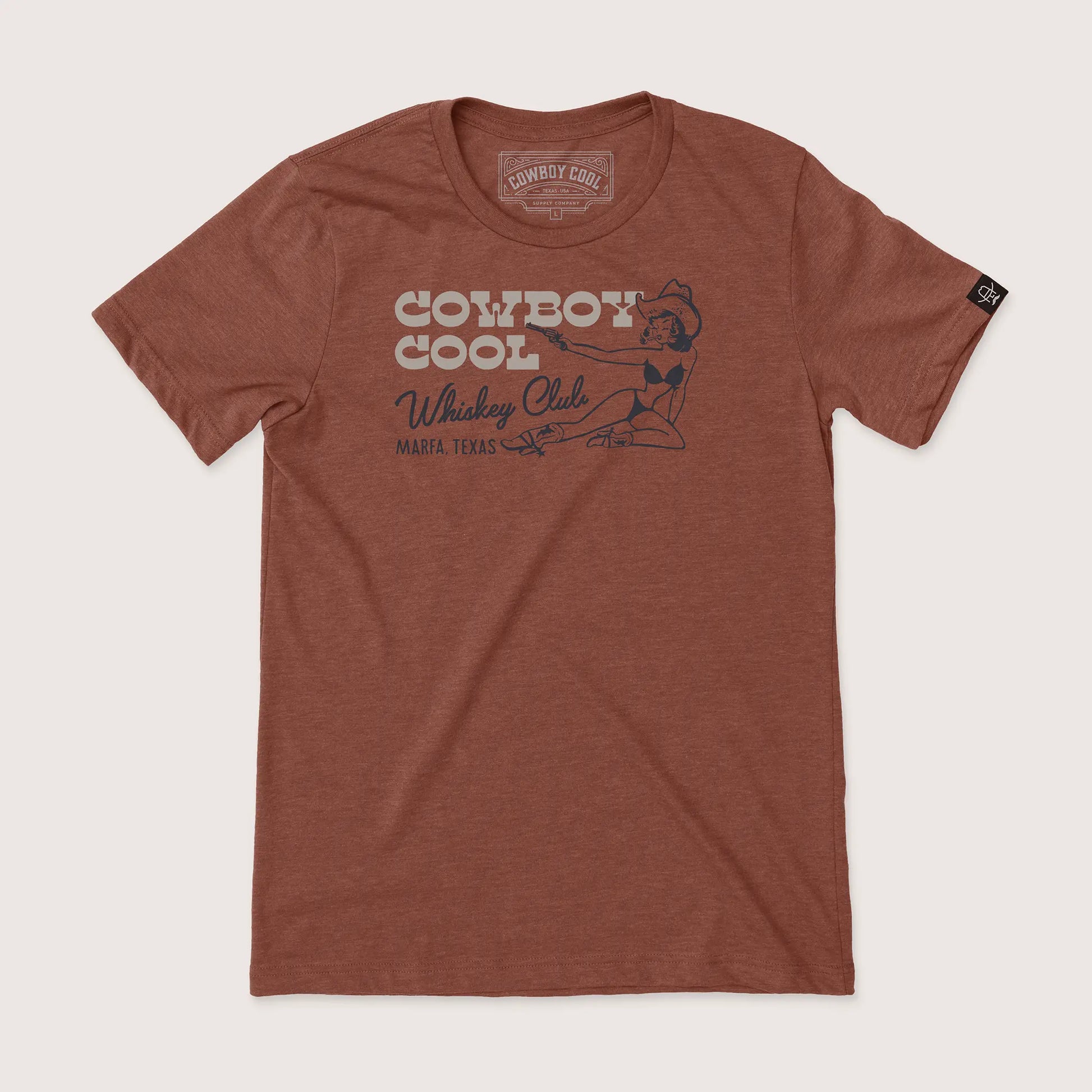 Cowboy Cool Whiskey Club T-Shirt in heather clay, featuring a retro-style western cowgirl with pistol graphic and 'Marfa, Texas' lettering on the chest.