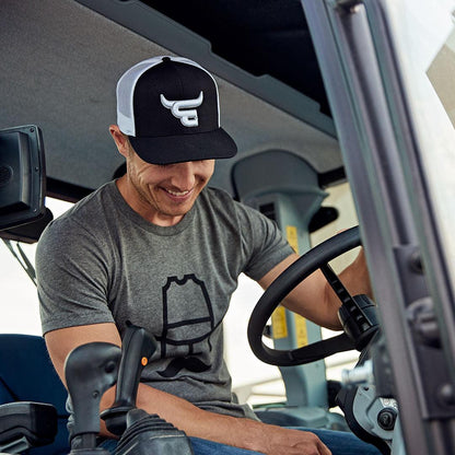 Man in tractor wearing Cowboy Cool El Toro Snapback hat.