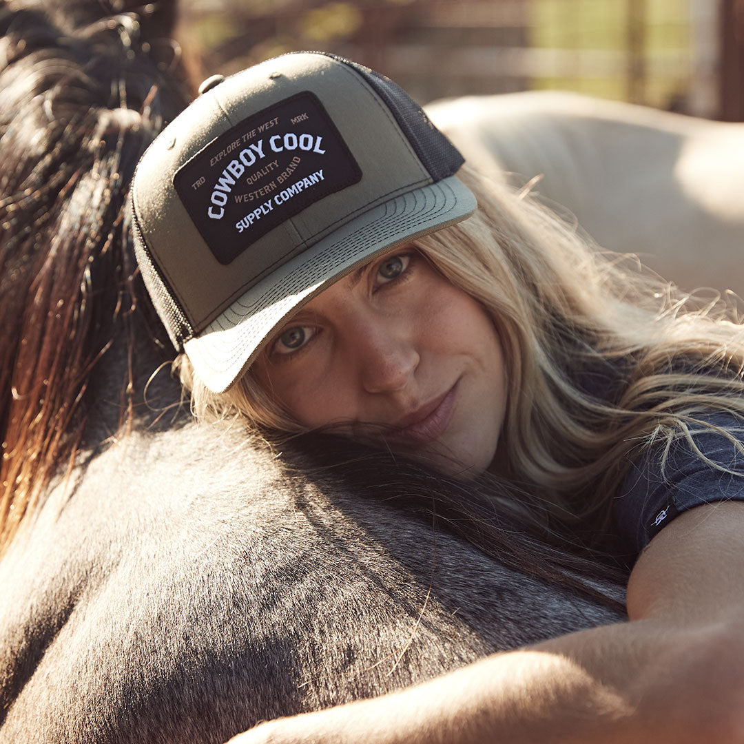 Model laying on horse wearing a Cowboy Cool Western Reserve Hat In Loden and Black